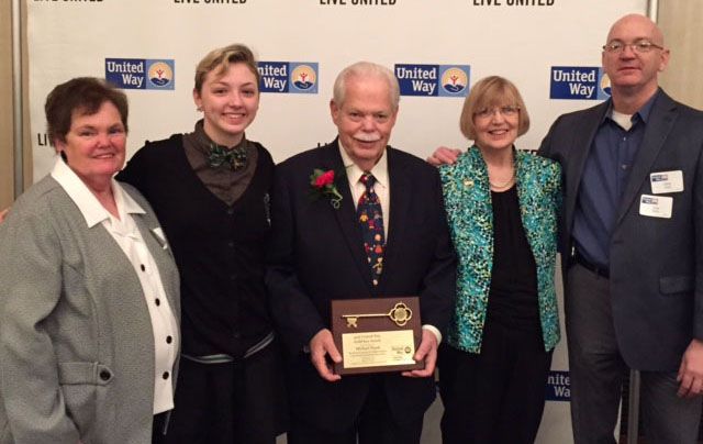 Group of five people pose with an award plaque for United Way, smiling and celebrating.