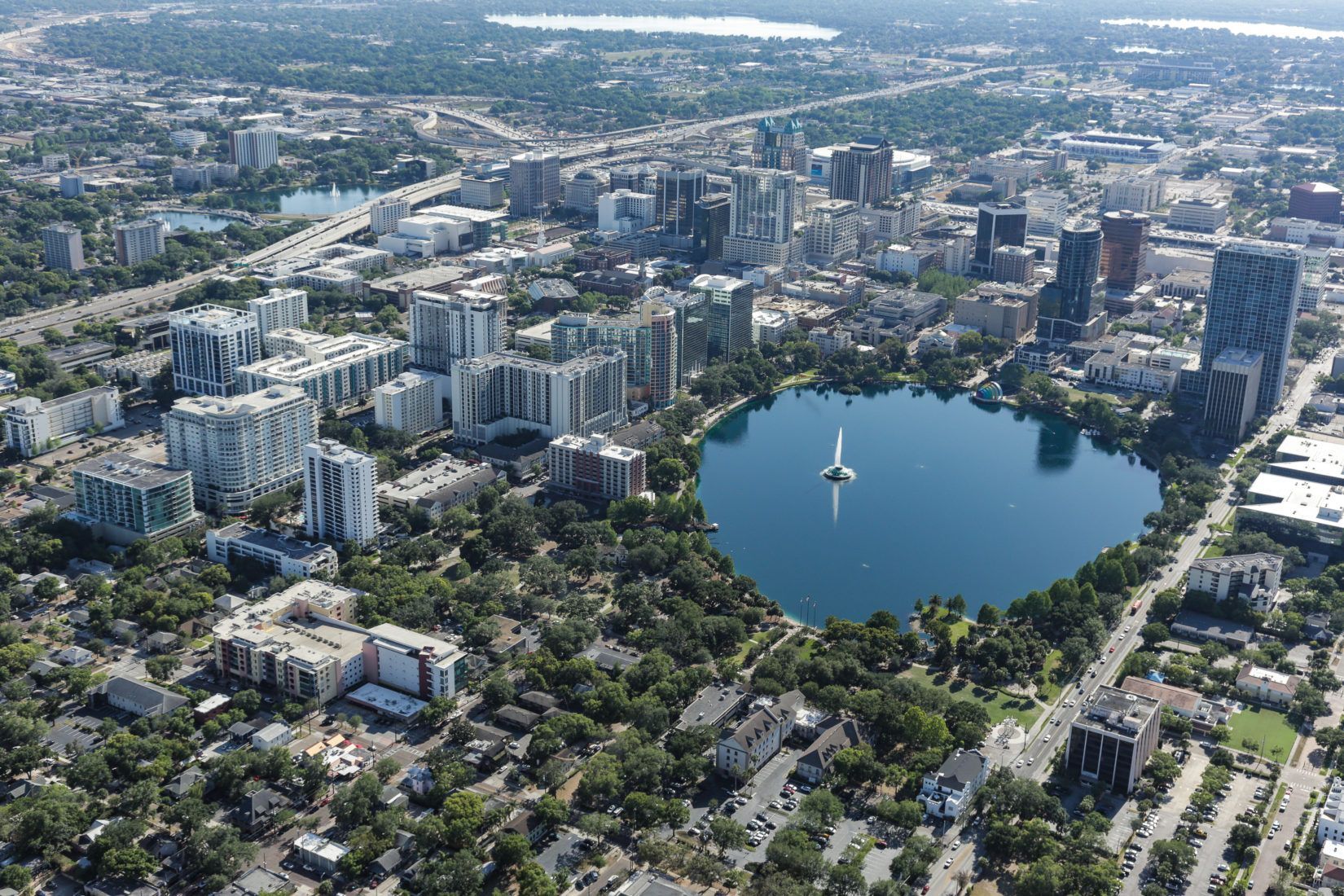 Aerial view of Orlando, Florida, with buildings, Lake Eola, and surrounding green spaces.
