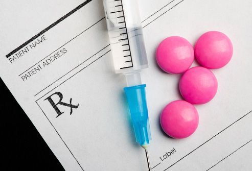 Prescription form with syringe and four pink pills.