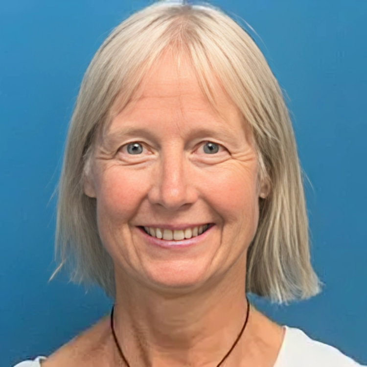 Smiling woman with short blonde hair, blue background.