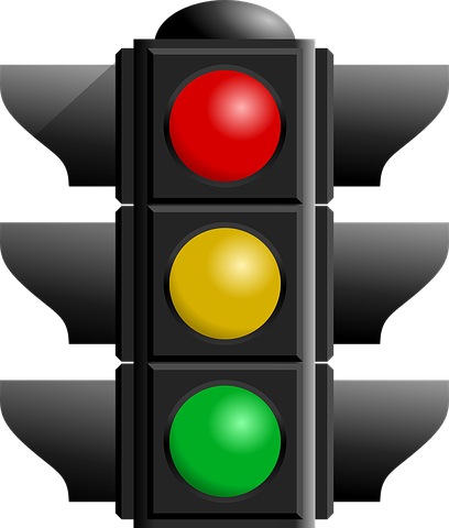 Traffic light showing red, yellow, and green lights illuminated.