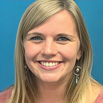 Woman with blonde hair smiling, wearing earrings, pink shirt, blue background.
