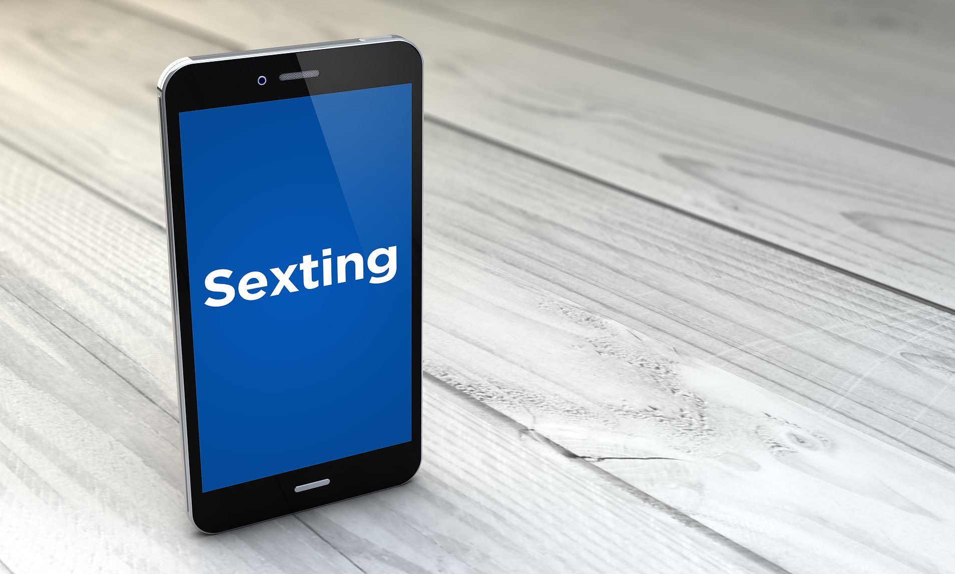 Smartphone on a wooden surface displays the word