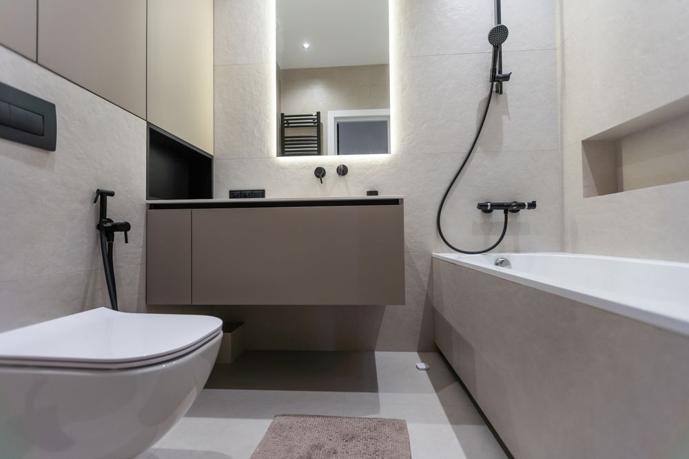 Modern bathroom with toilet, floating vanity, mirror, and bathtub with black shower fixtures.