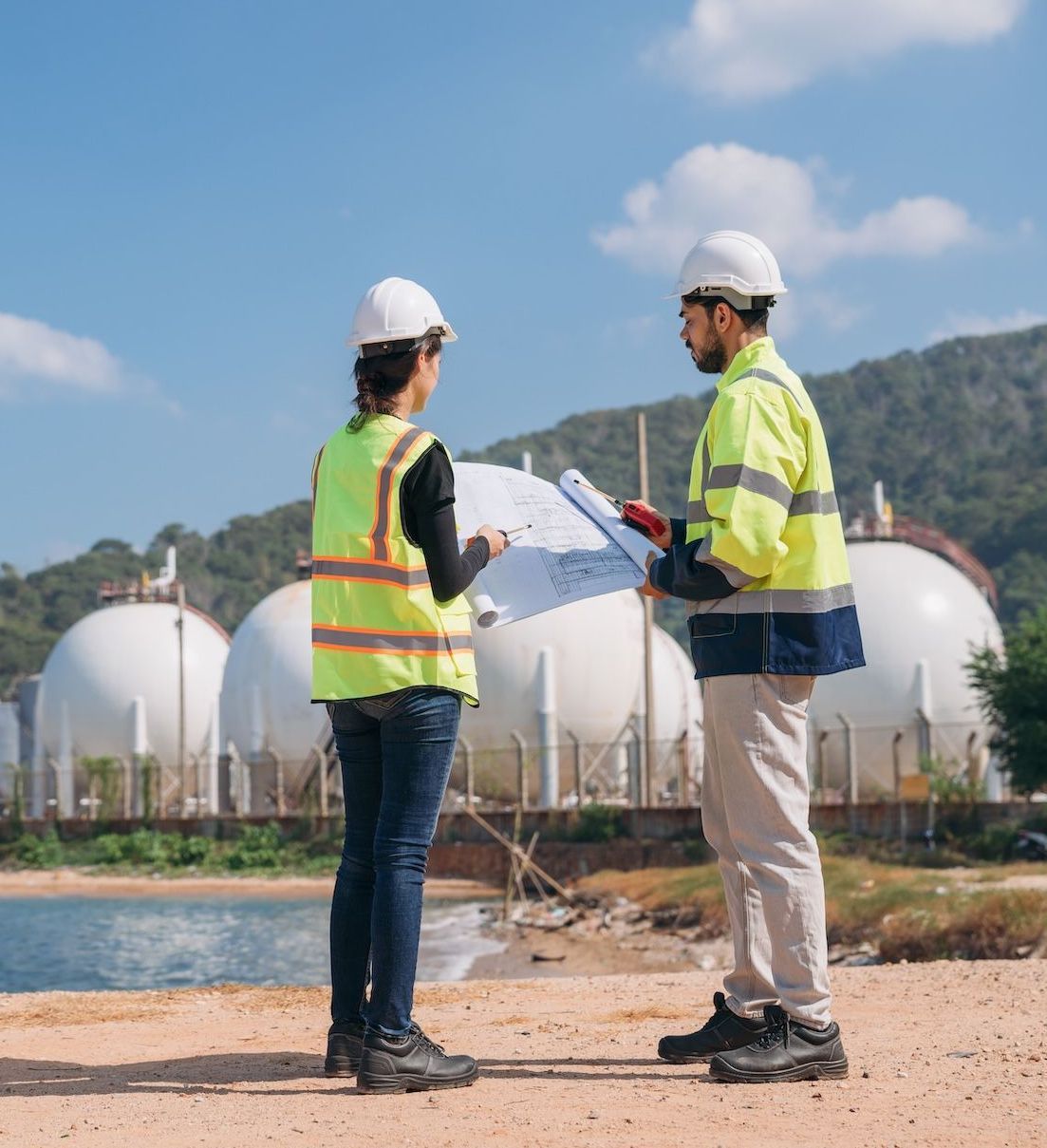 Two people are consulting in front of natural gas containers