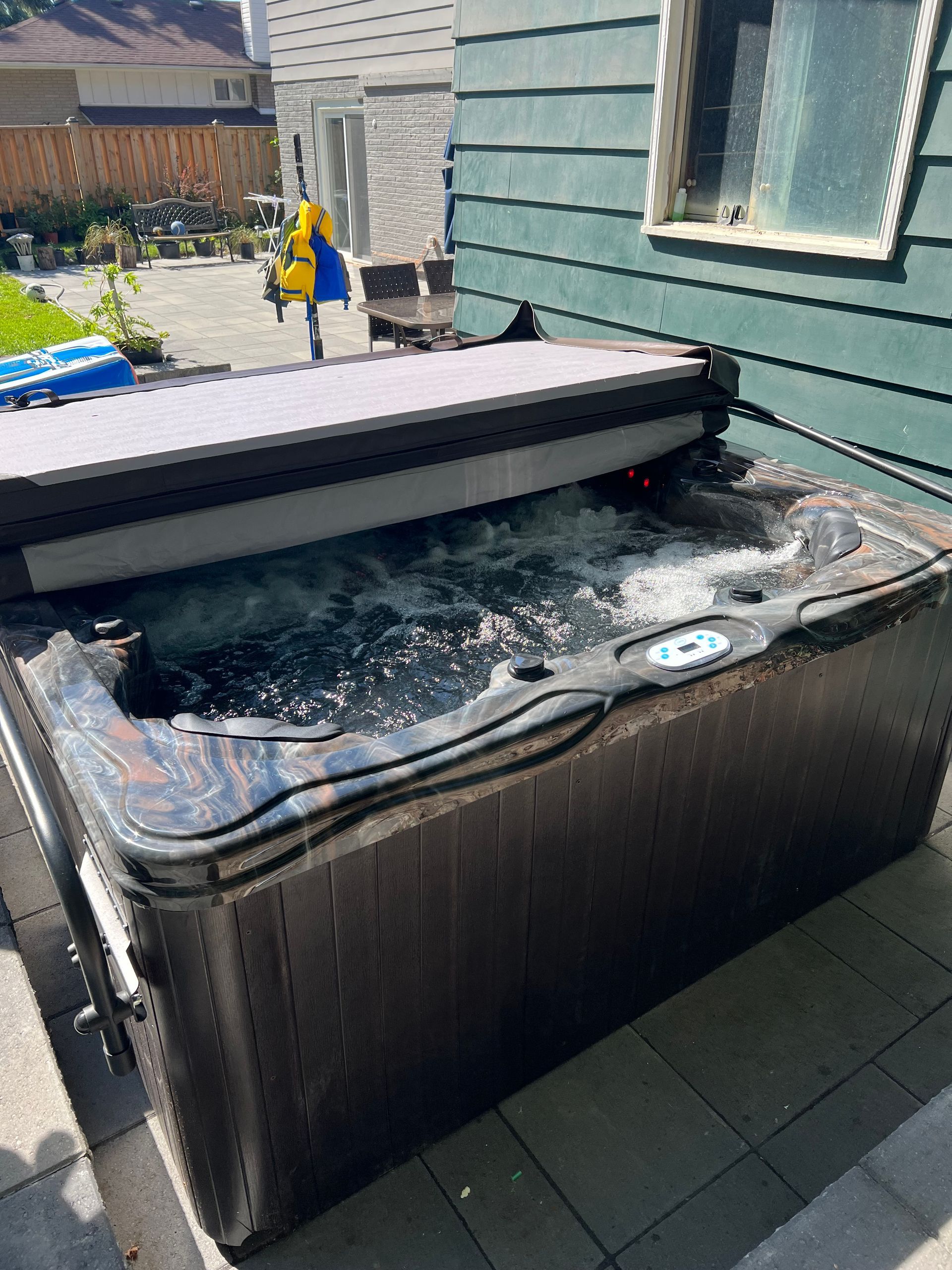 A hot tub is sitting outside of a house.