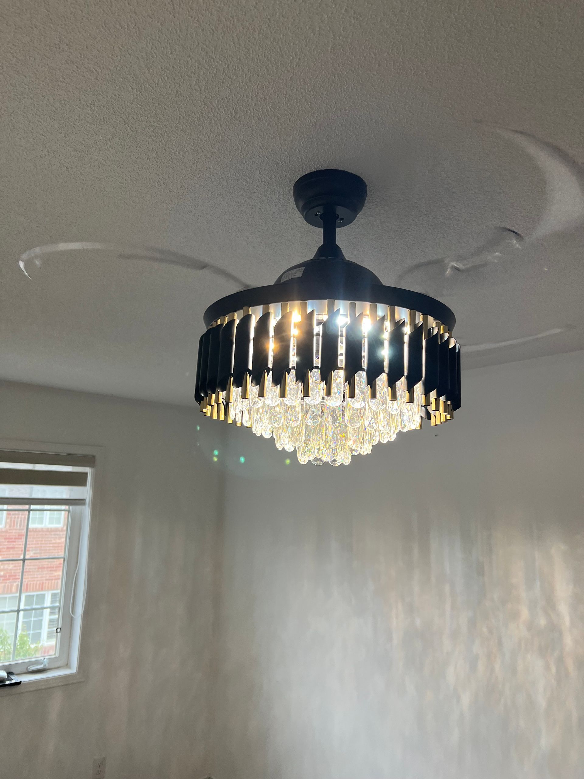 A ceiling fan with a chandelier attached to it is hanging from the ceiling in a room.