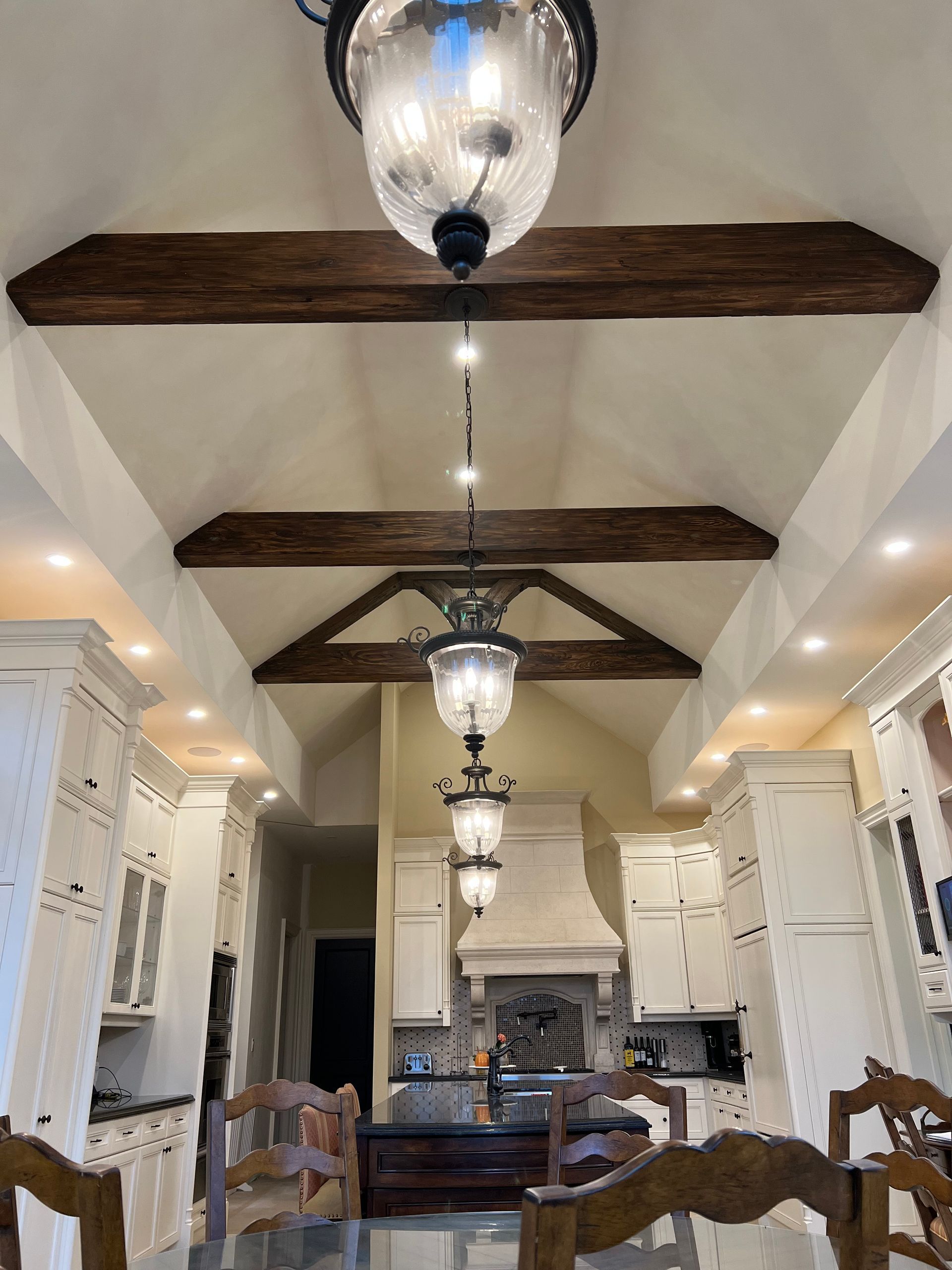 A kitchen with a table and chairs and a chandelier hanging from the ceiling.