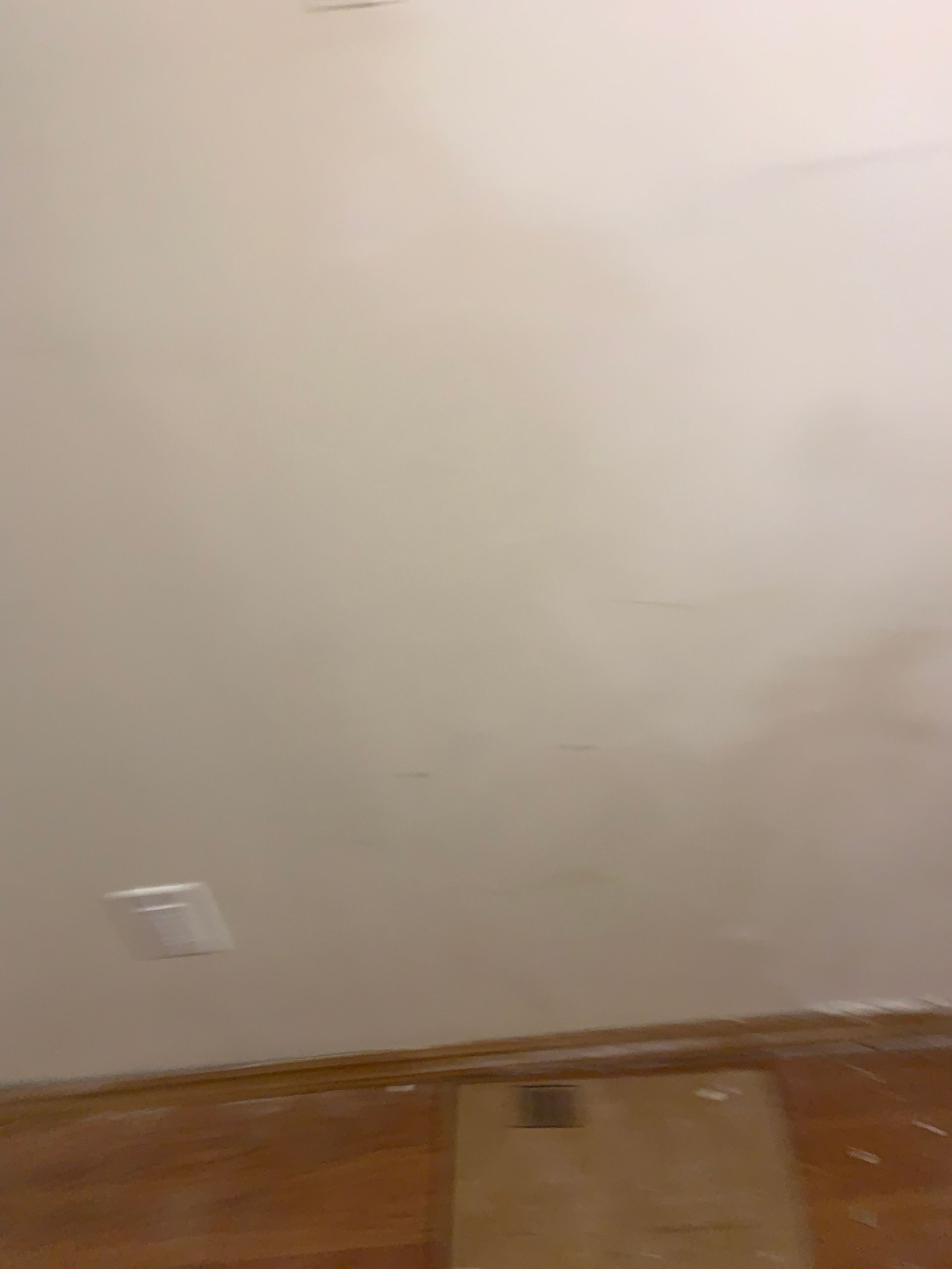 A room with a white wall and a wooden floor.