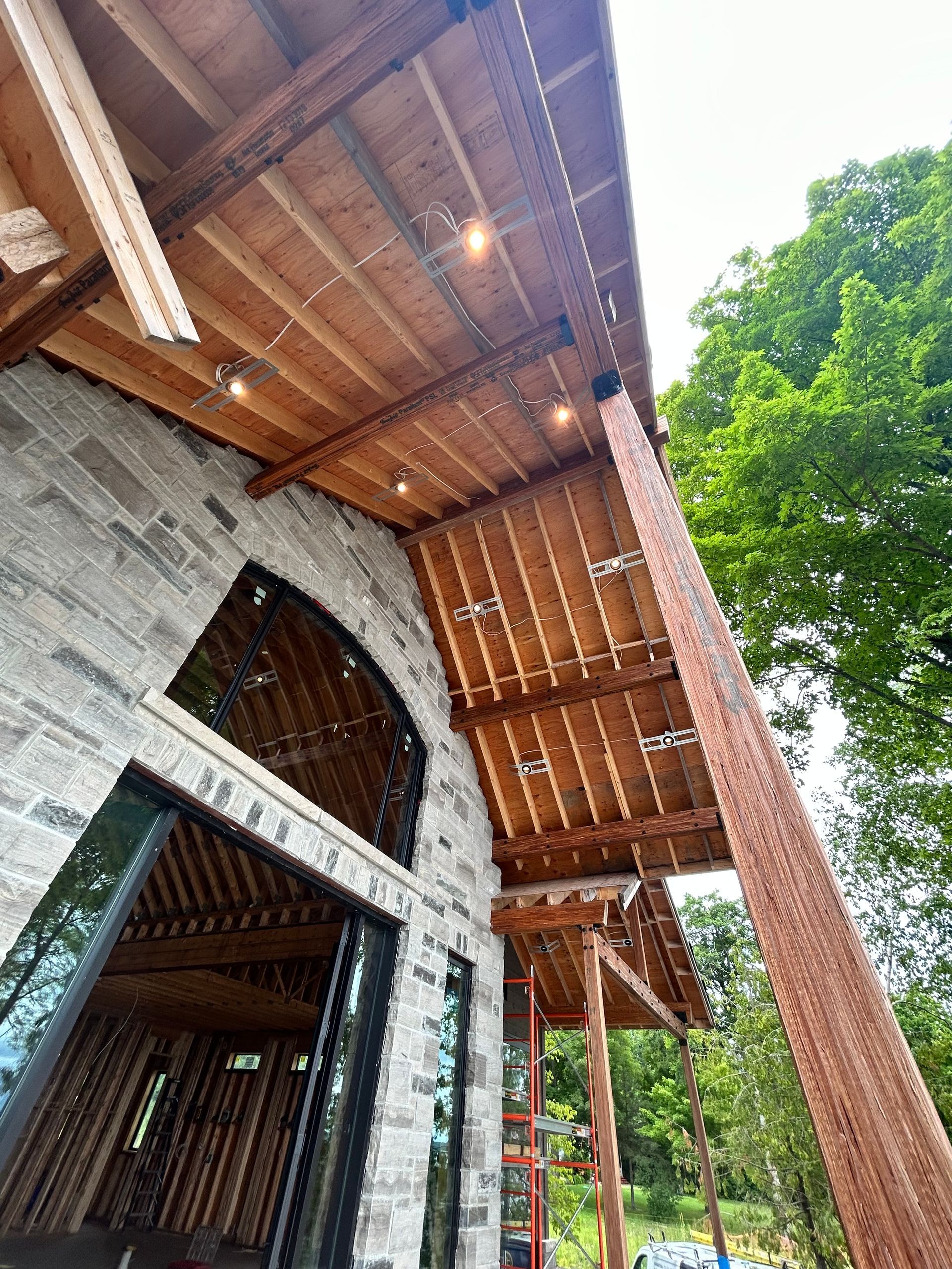 A building under construction with a wooden roof and a ladder.