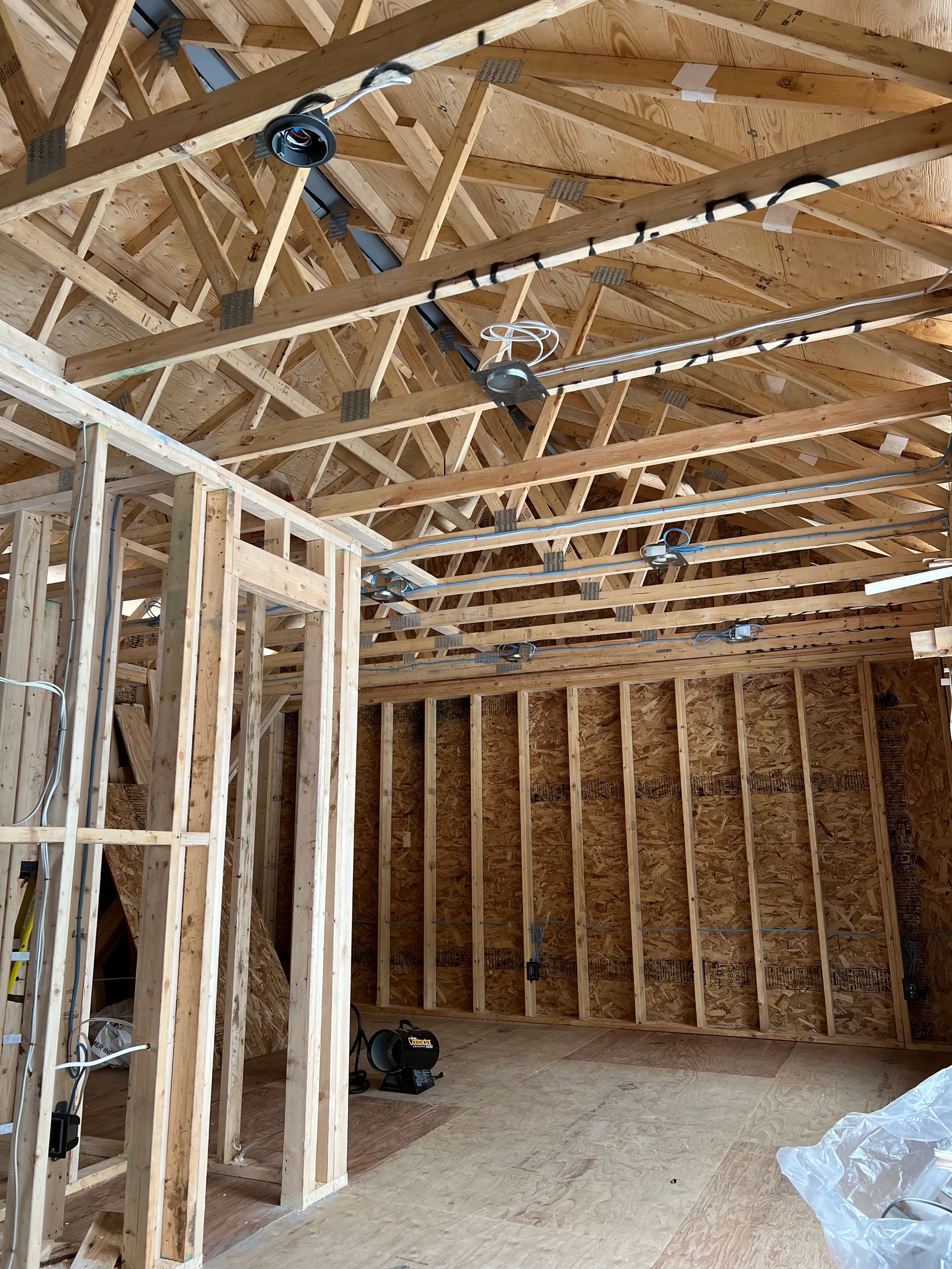 A room in a house under construction with a lot of wooden beams.