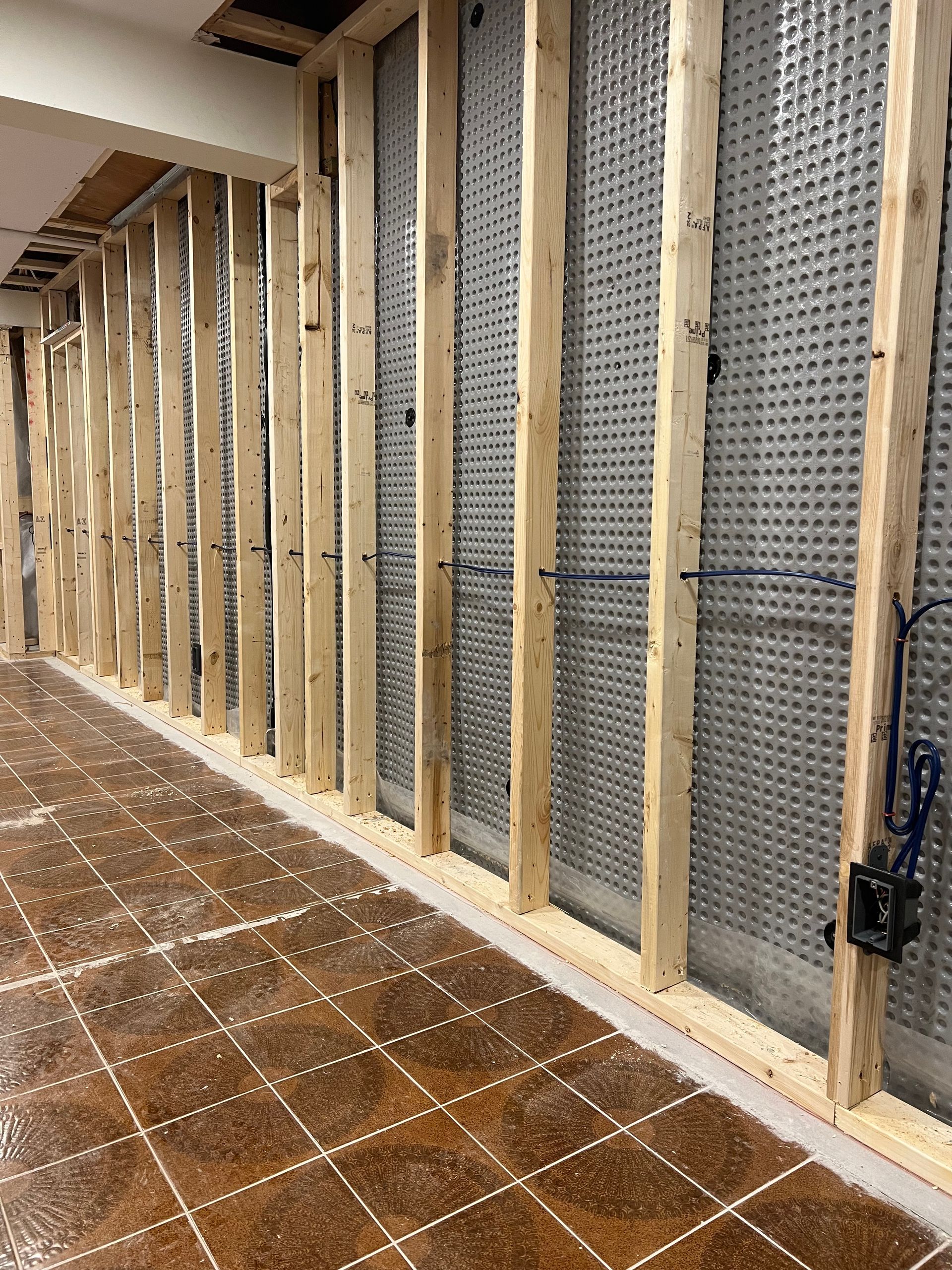 A room with a tiled floor and a wall with wooden beams.