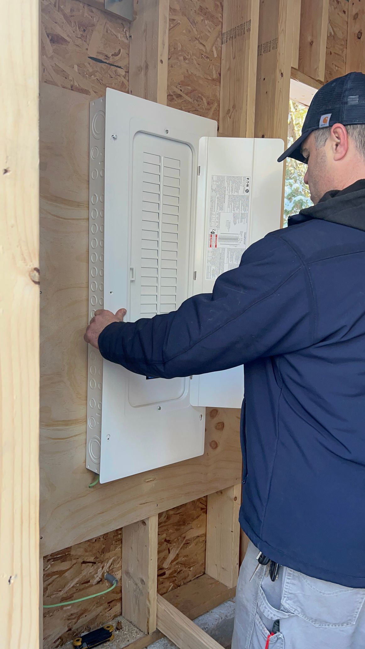 A man is installing an electrical box on a wall.
