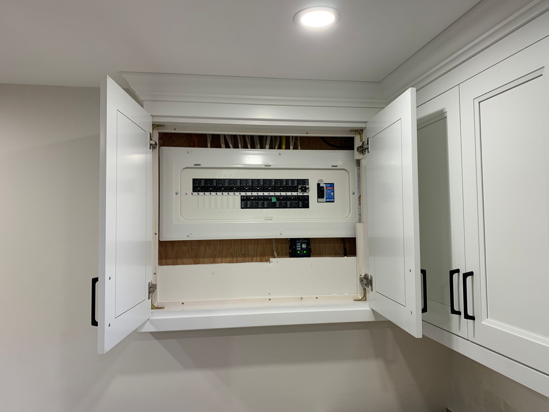 A white cabinet with a electrical box inside of it.