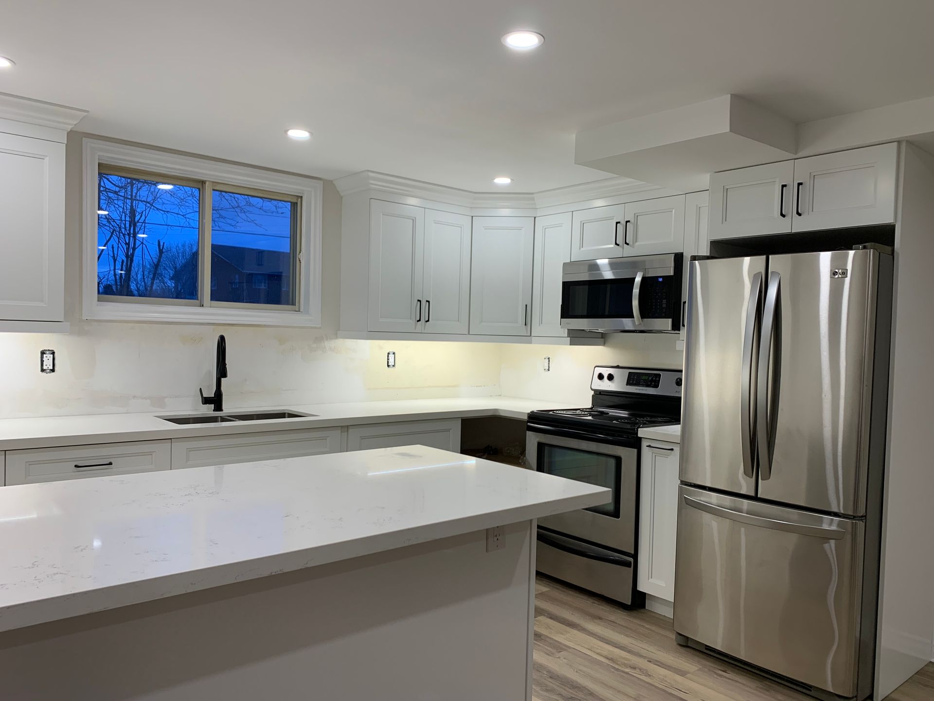 A kitchen with stainless steel appliances and white cabinets.