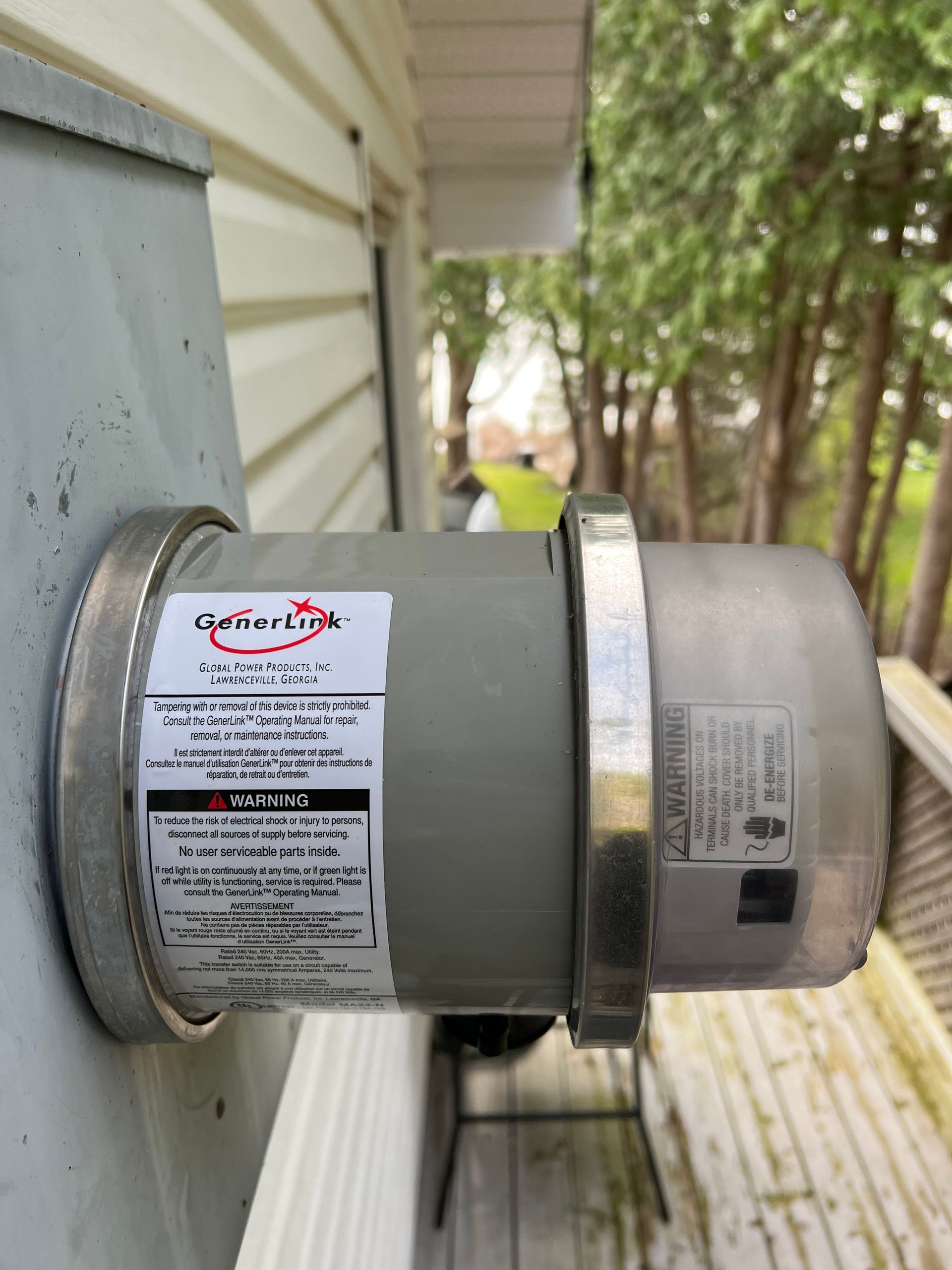 A stainless steel exhaust fan is attached to the side of a house.