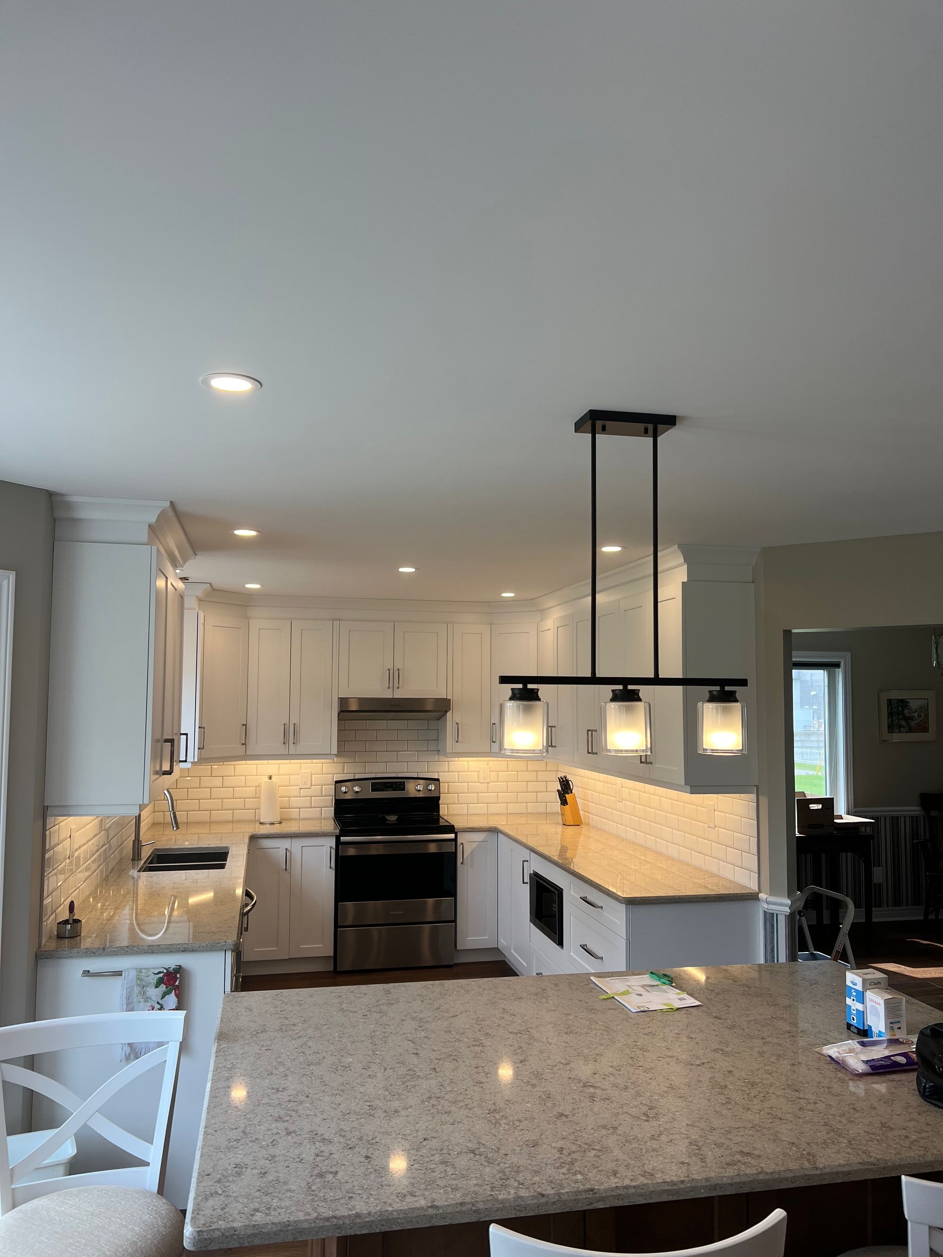 A kitchen with granite counter tops and white cabinets