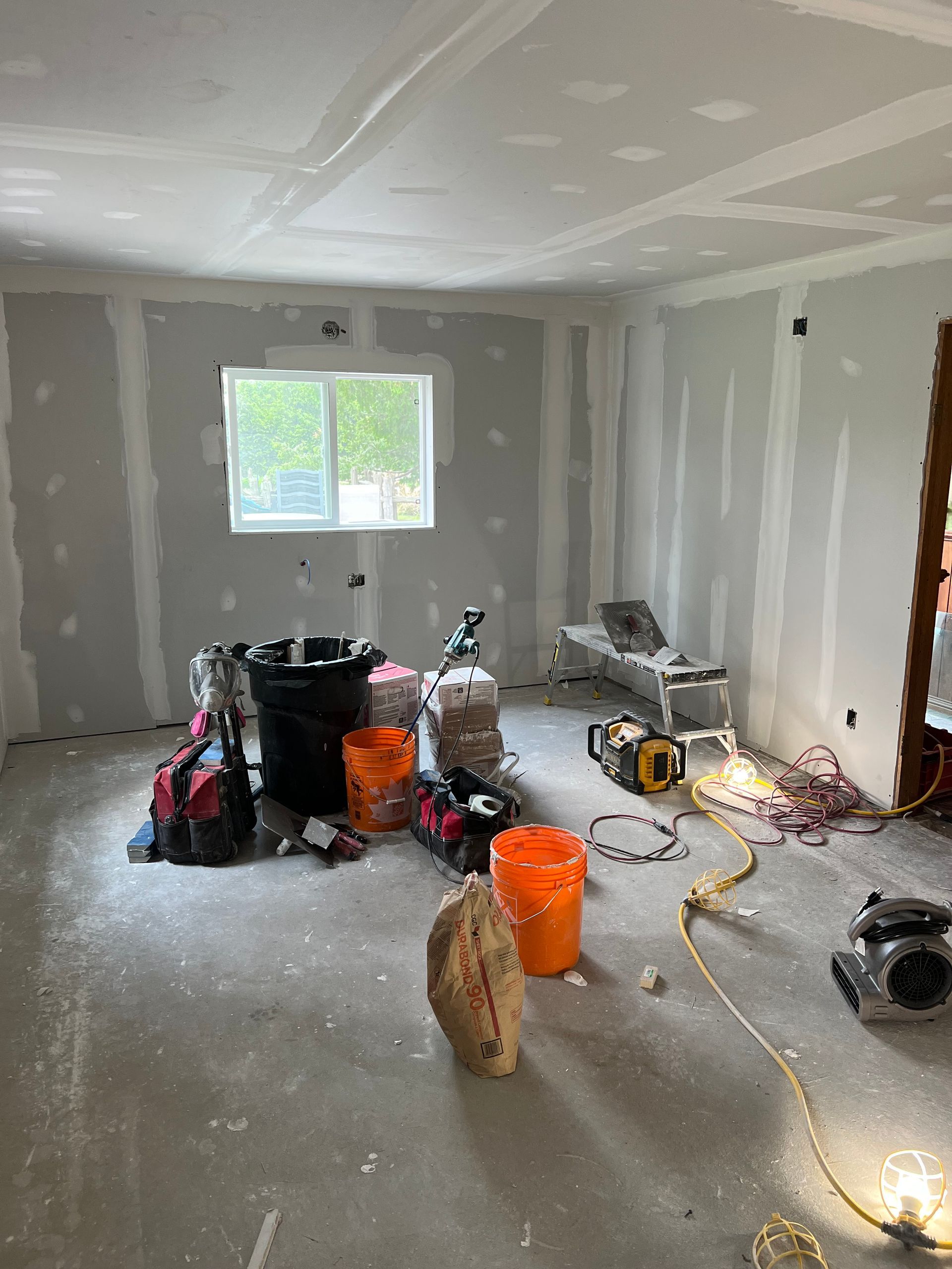 A room with a lot of tools and buckets on the floor.