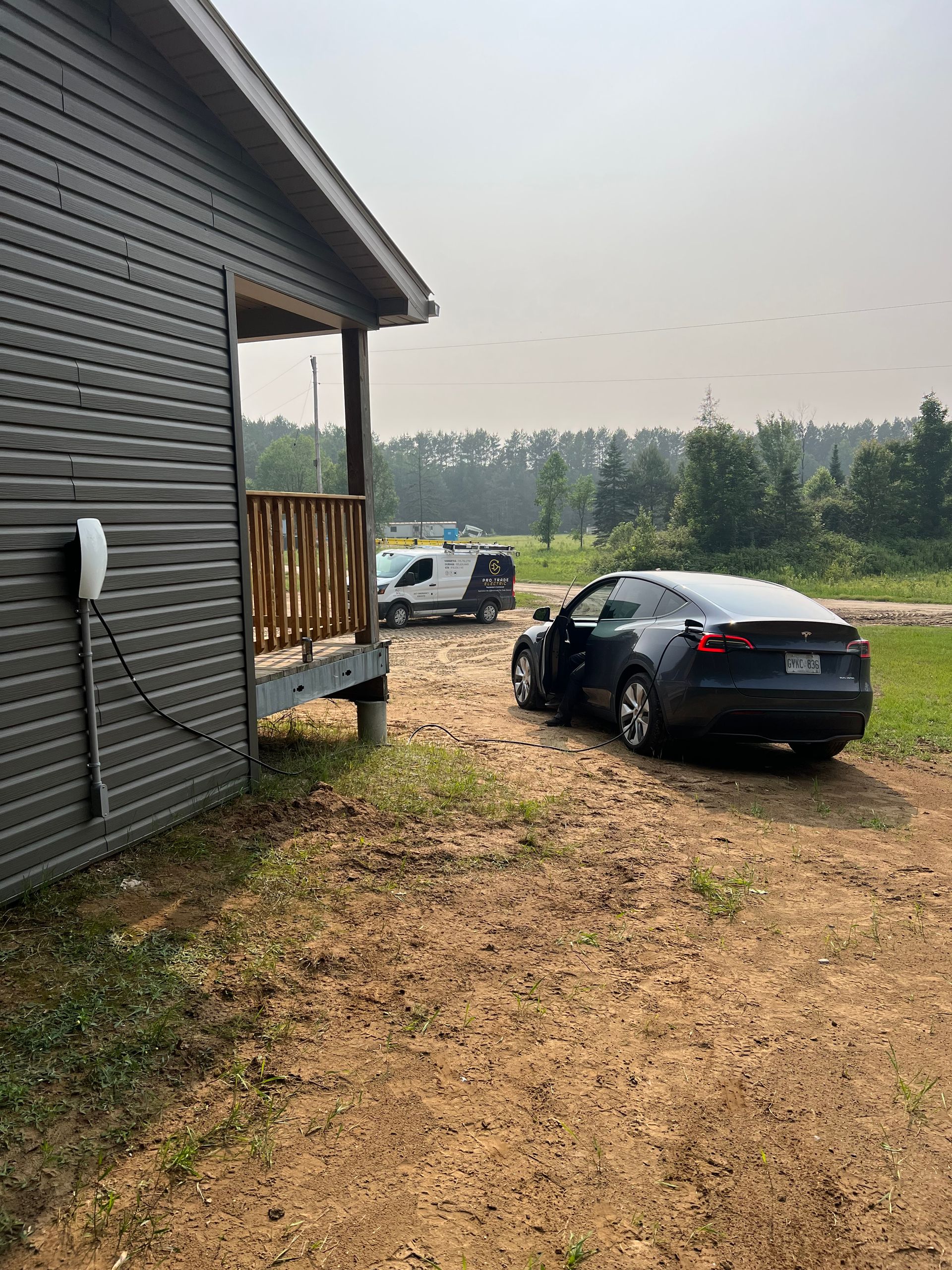 A tesla model 3 is parked in front of a house.