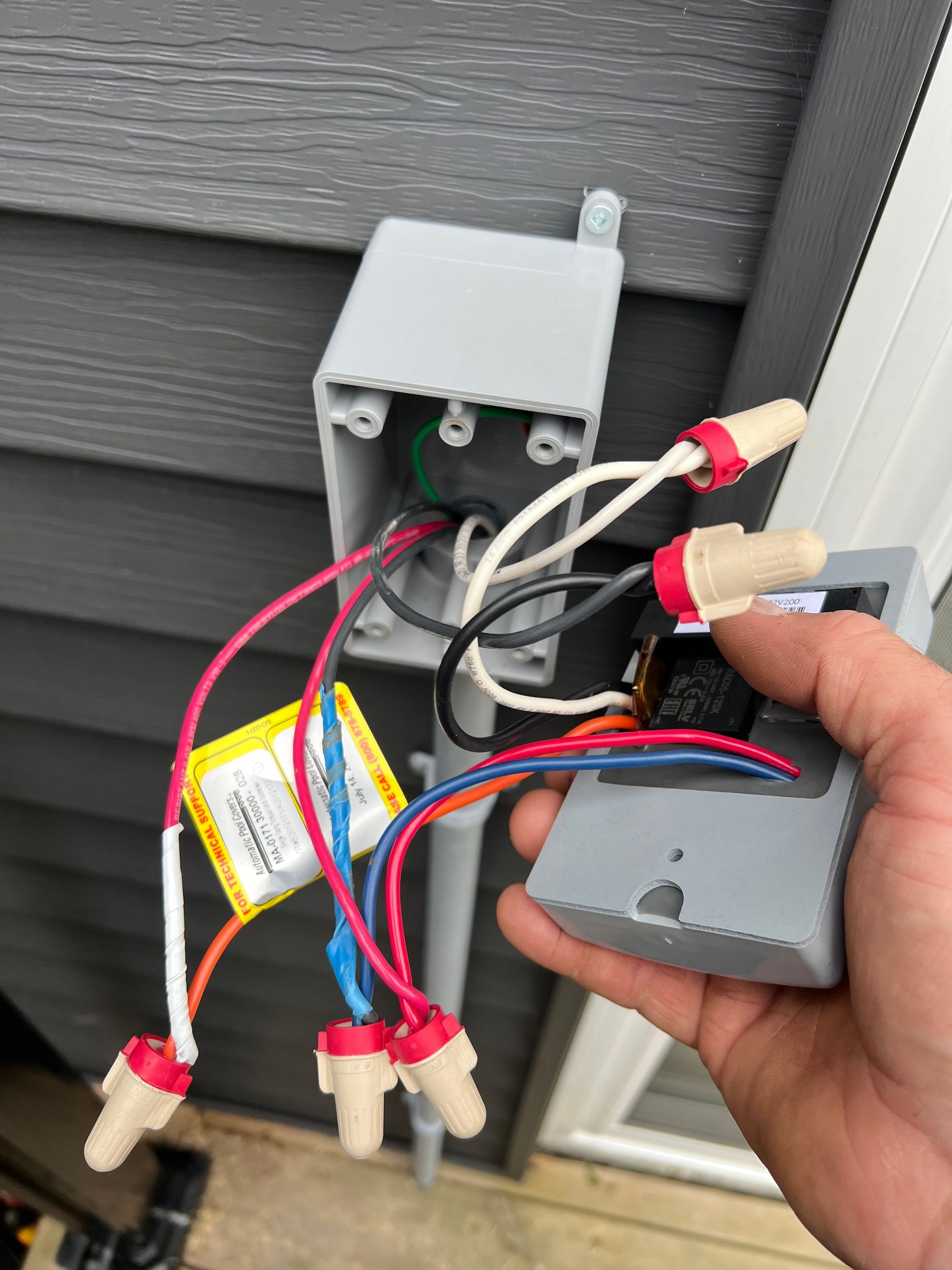 A person is holding a box with wires coming out of it.