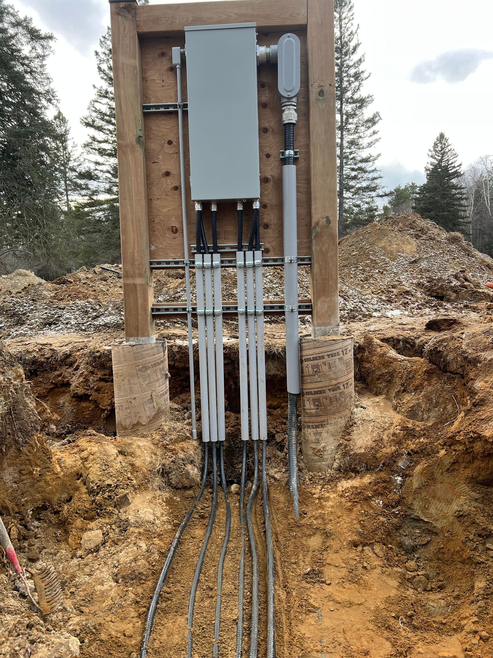A bunch of wires are coming out of a hole in the ground.