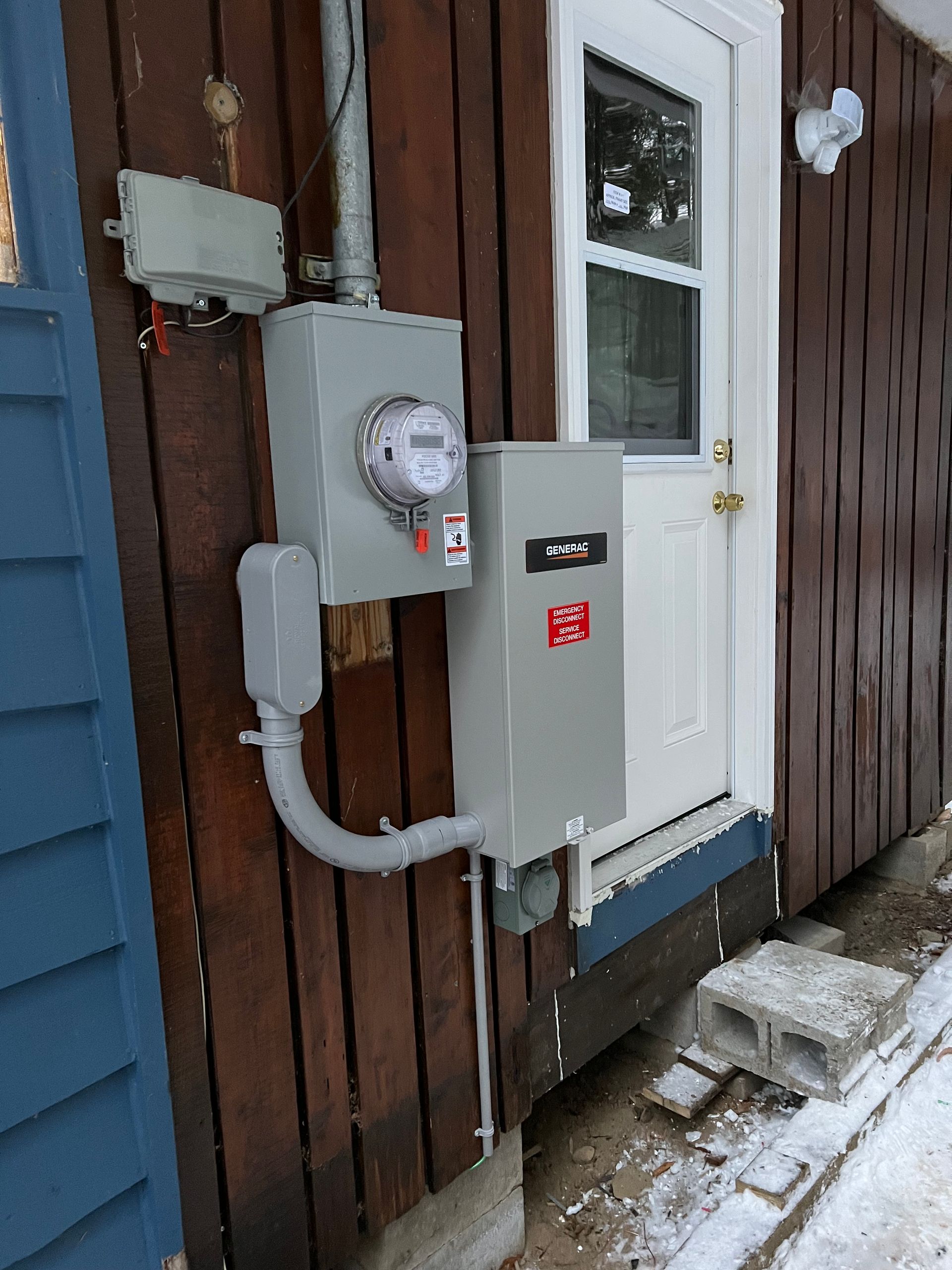 A meter is attached to the side of a house.