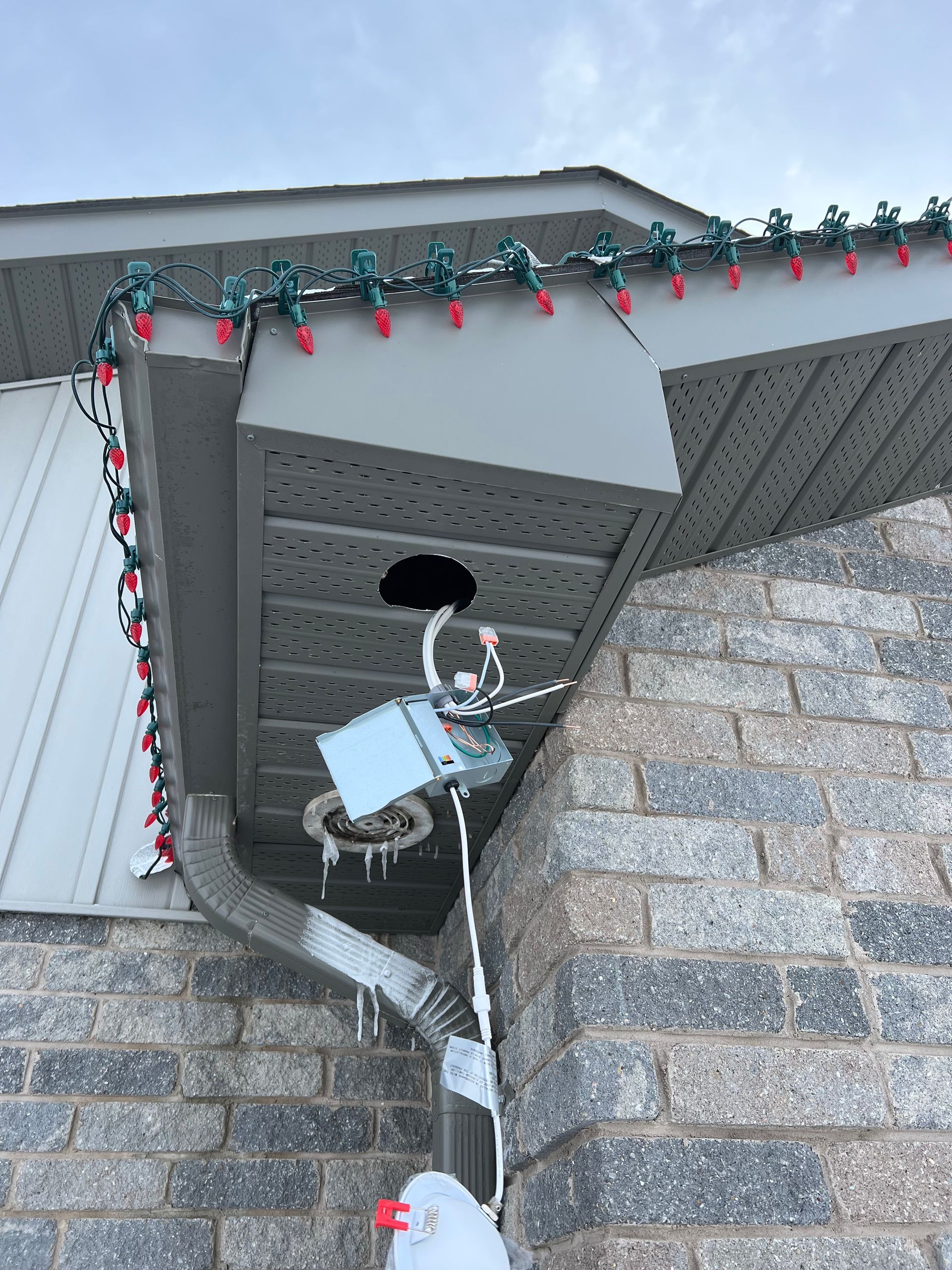 A house with christmas lights on the roof and gutters.