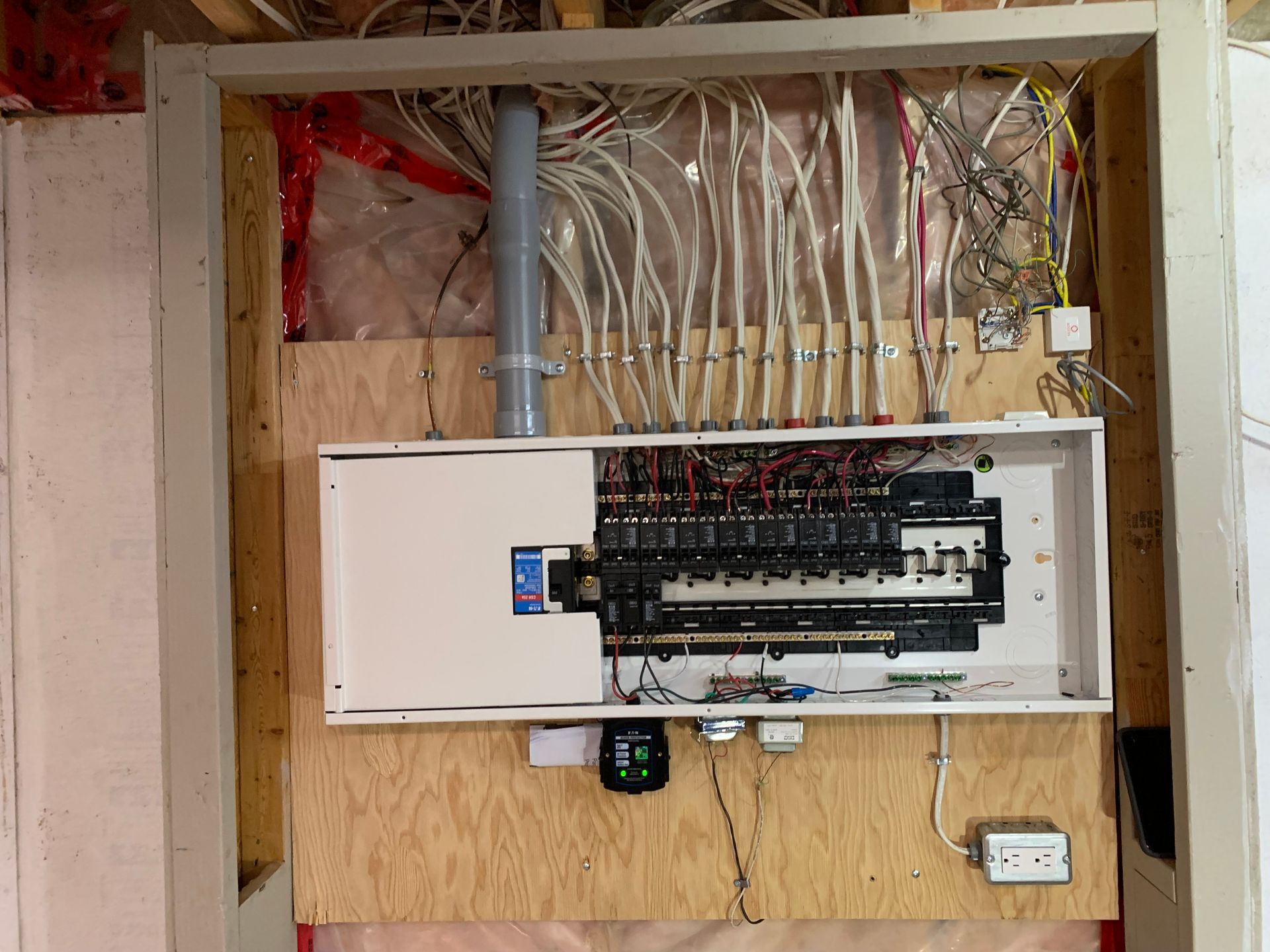 A white electrical box is sitting on a wooden wall.