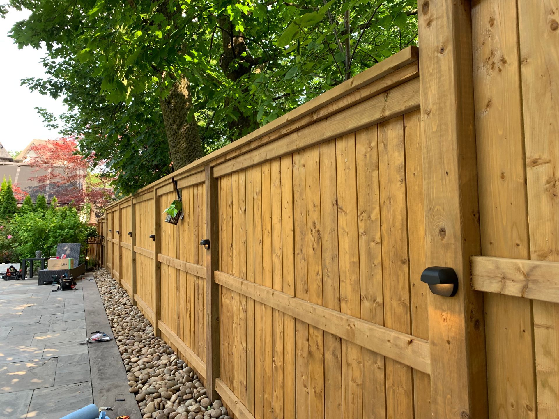 A wooden fence is surrounded by rocks and trees.