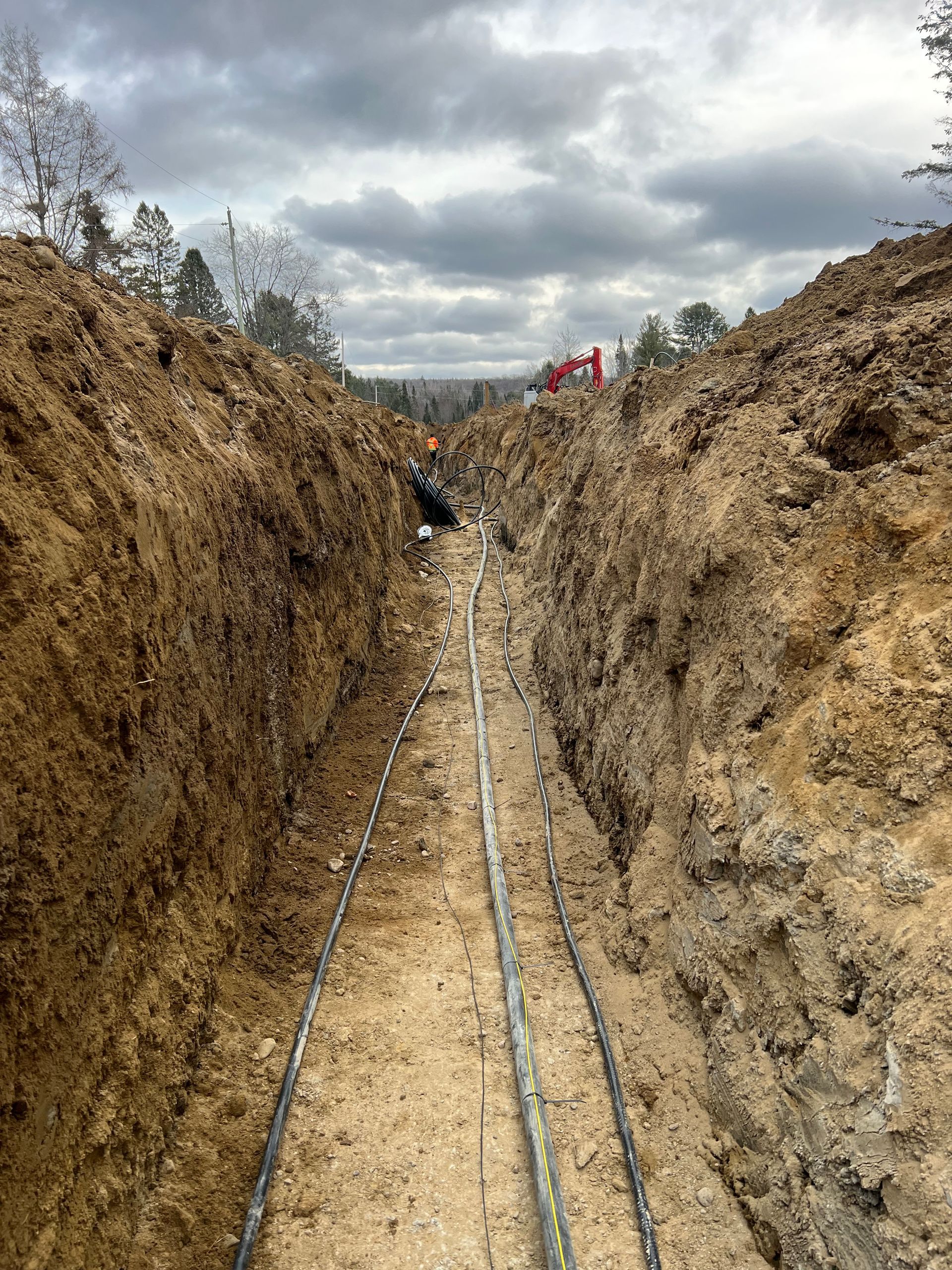 A trench filled with dirt and electrical wires.