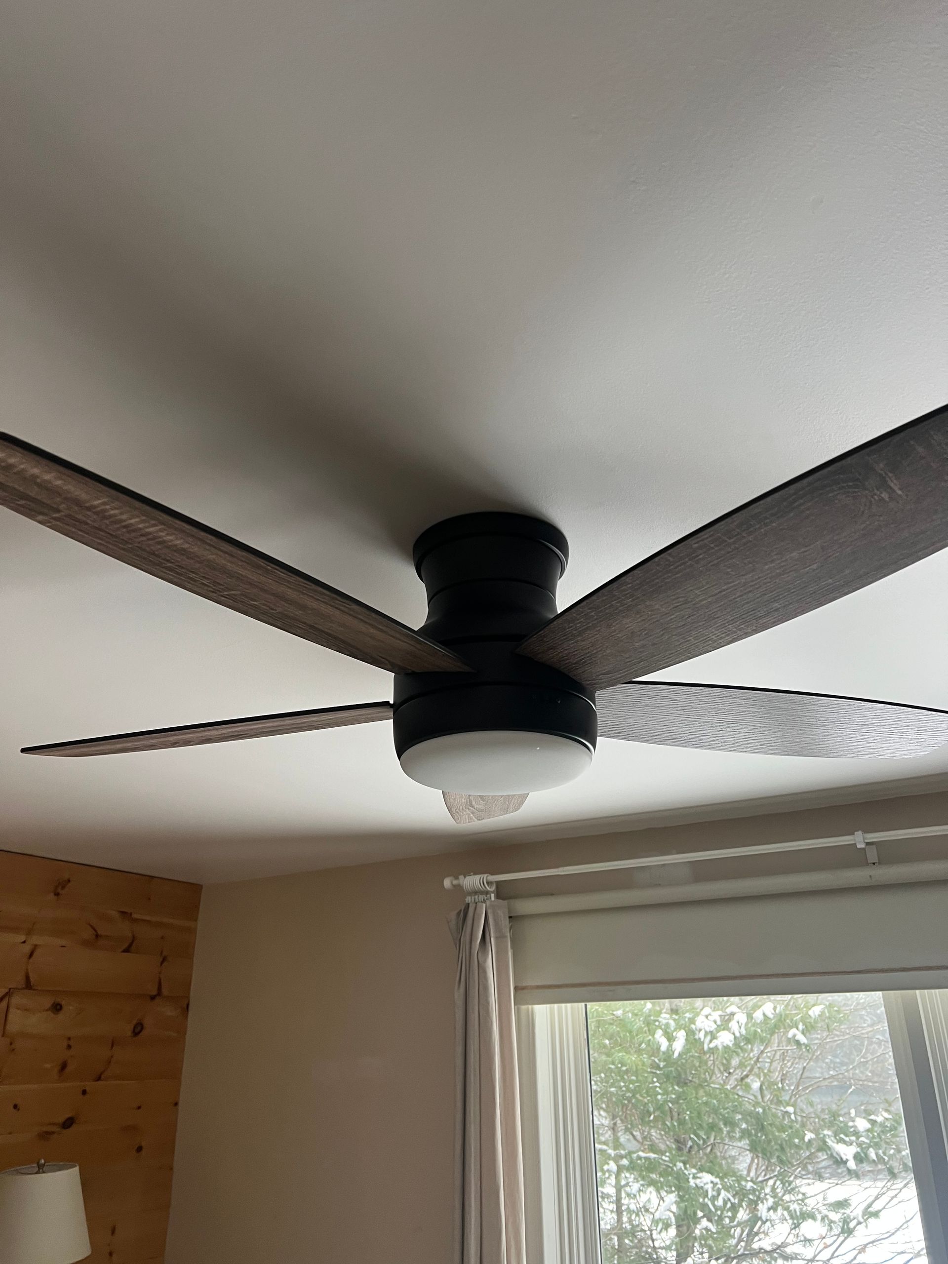 A ceiling fan is hanging from the ceiling in a living room.
