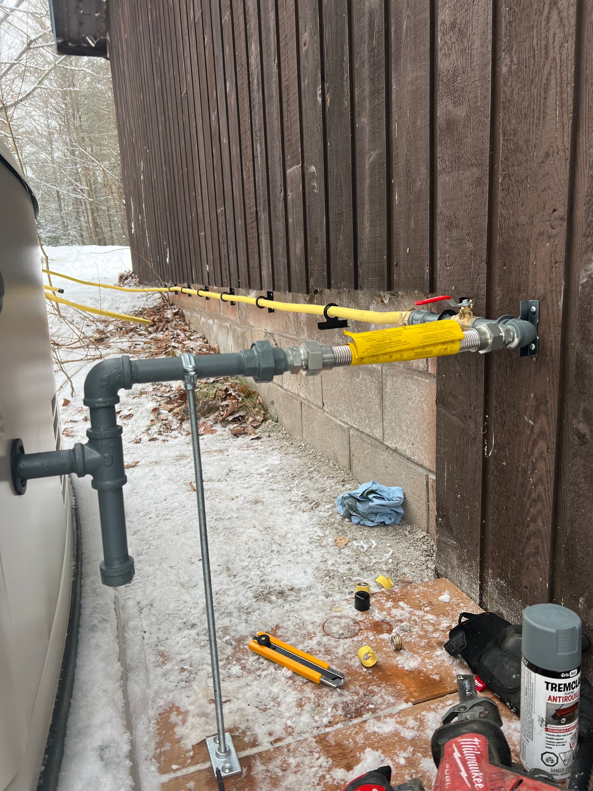 A pipe is being installed on the side of a building