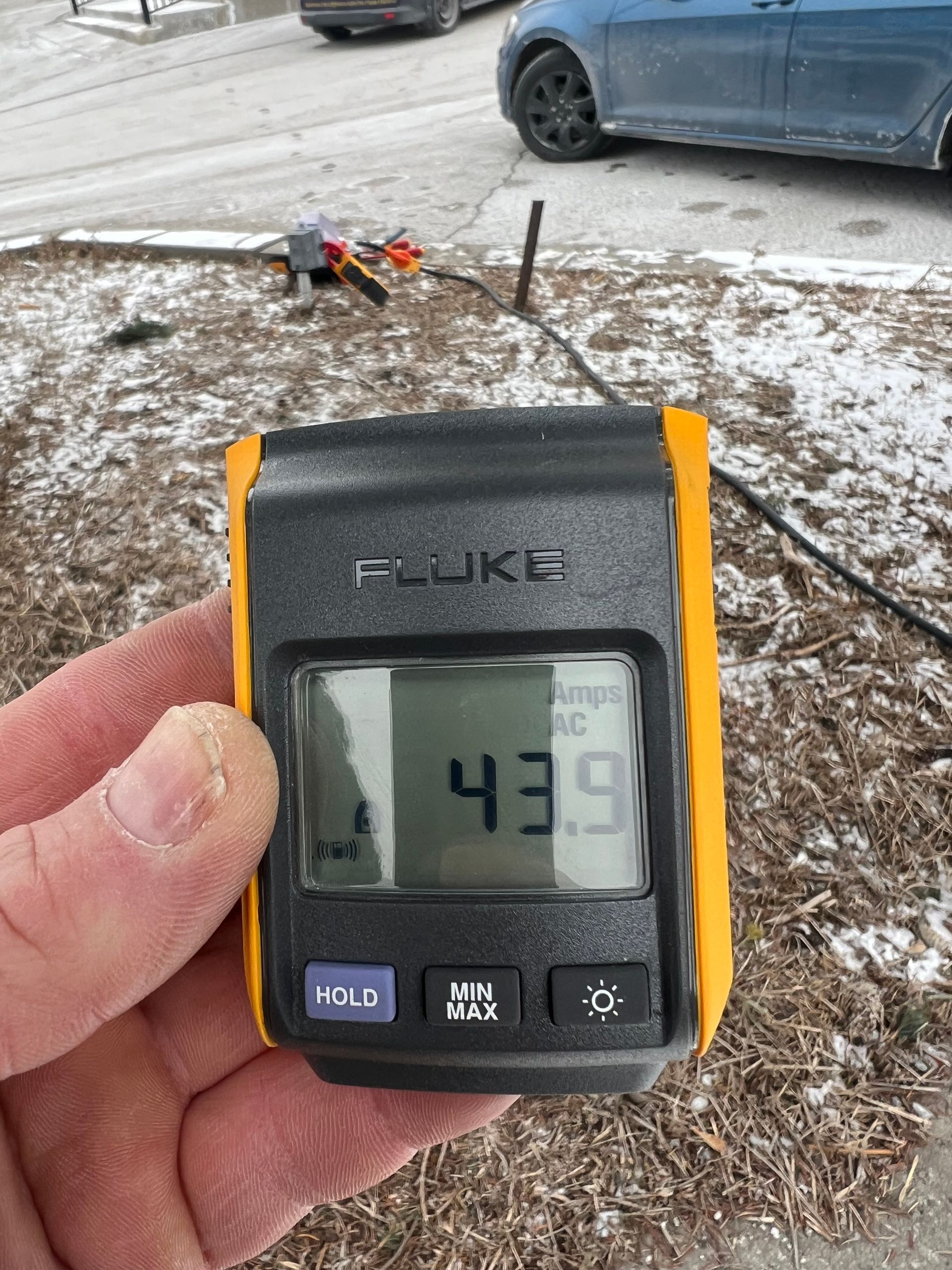 A person is holding a fluke device in their hand.