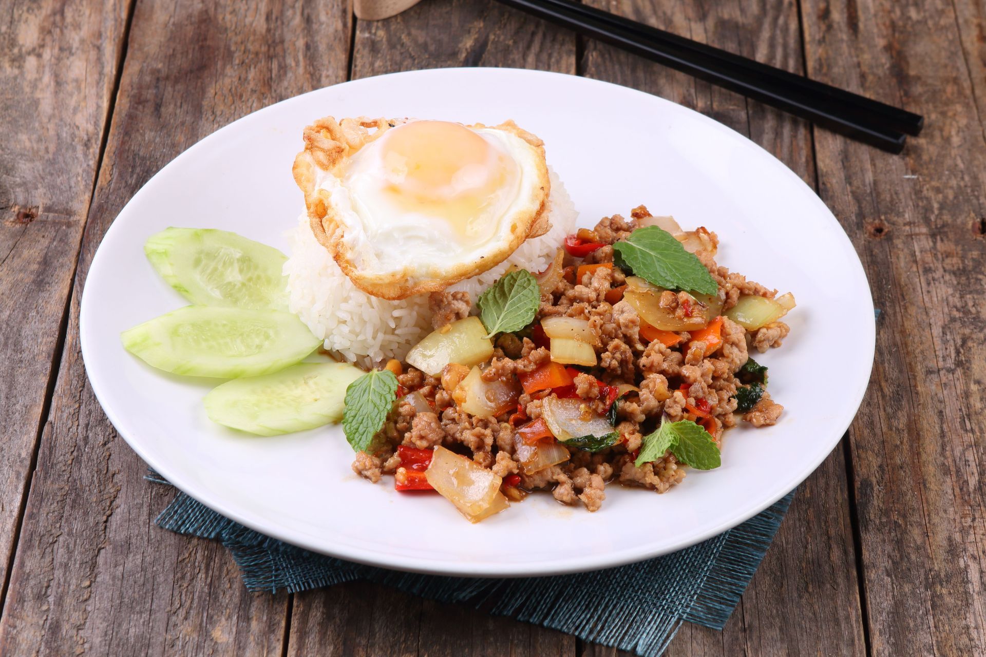 A plate of eggs, rice and vegetables on a wooden table