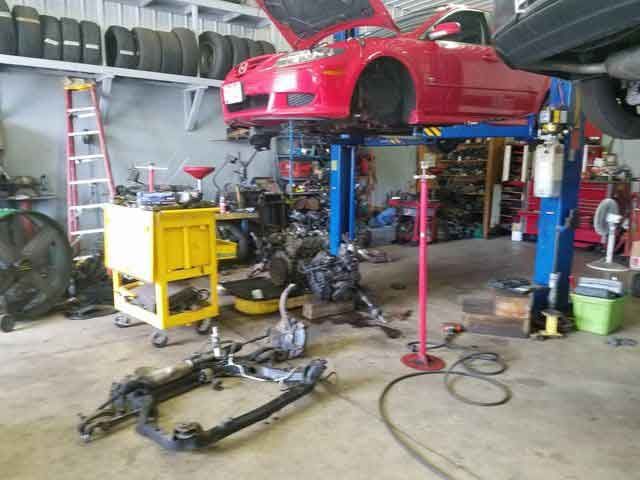 Red Car Lifted in Auto Repair Shop — Newark, OH — Eric’s Complete Auto Repair