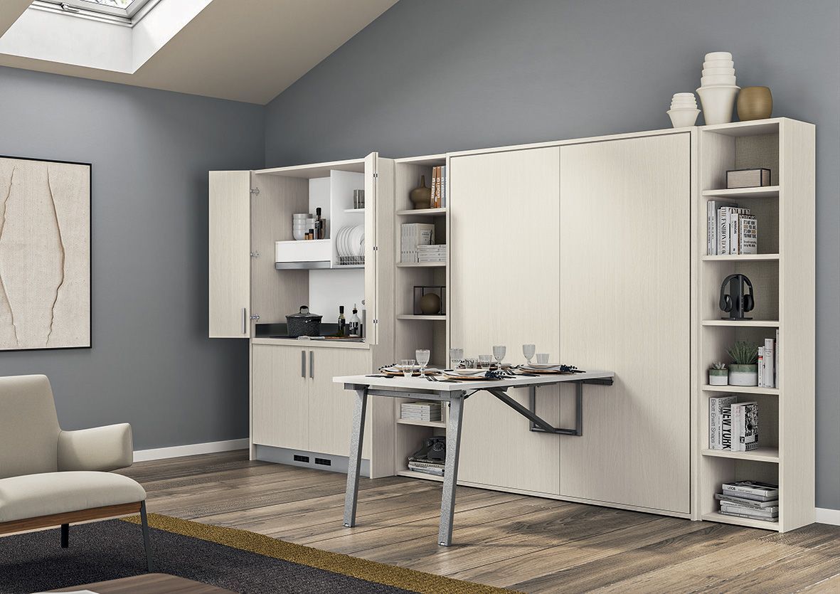 Appartamento moderno con cucina a scomparsa e tavolo incassato nel muro, colori crema e grigio, scaffali con libri e decorazioni.
