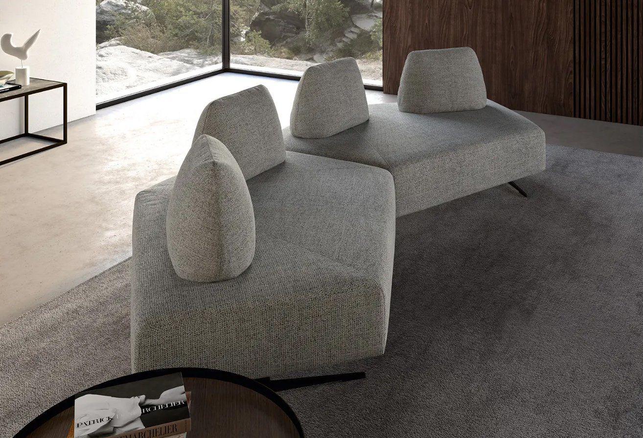 Divano modulare grigio moderno in un soggiorno minimalista.