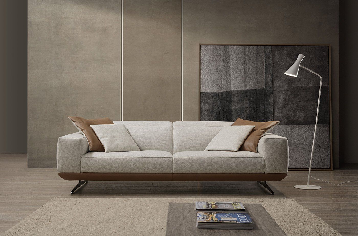 Divano beige con finiture e cuscini marroni in un soggiorno moderno. Sono presenti anche una lampada da terra e opere d'arte astratte.