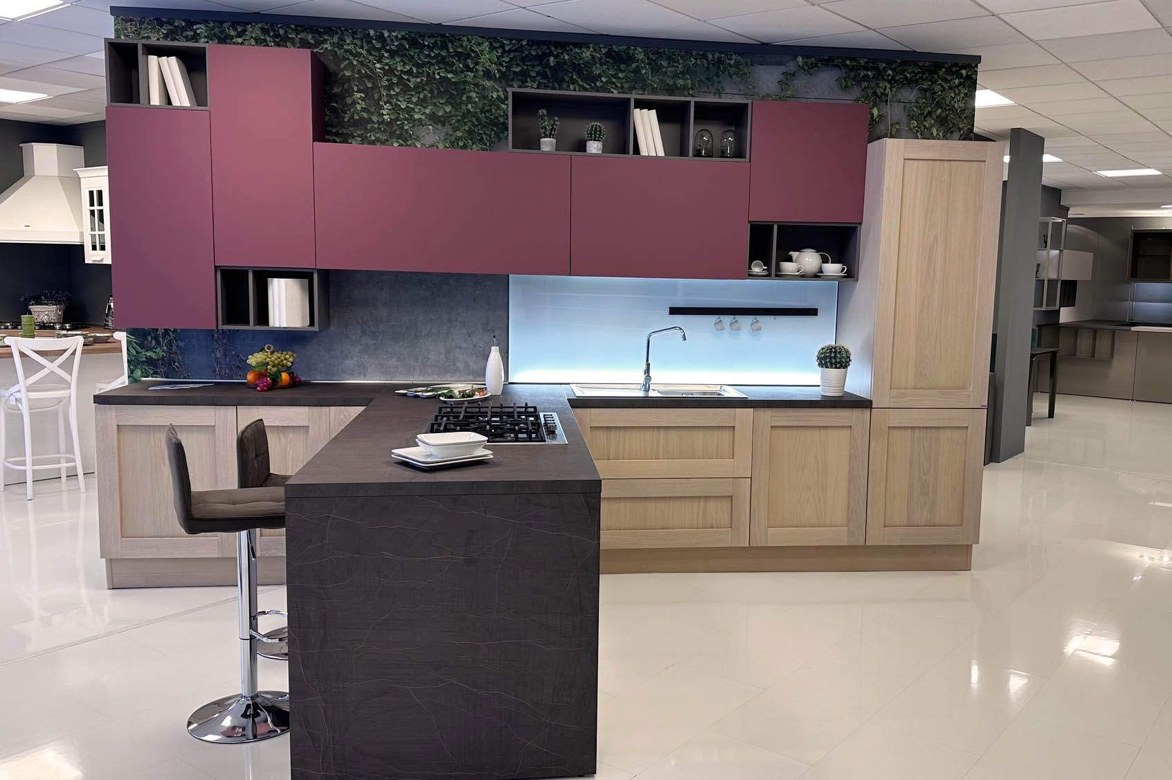 Cucina moderna con isola scura e pensili color prugna.
