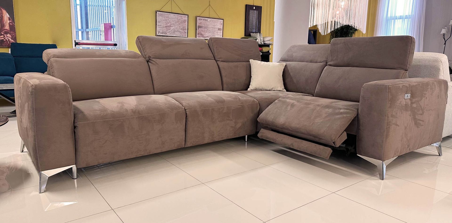Divano componibile marrone con funzione reclinabile in uno showroom.
