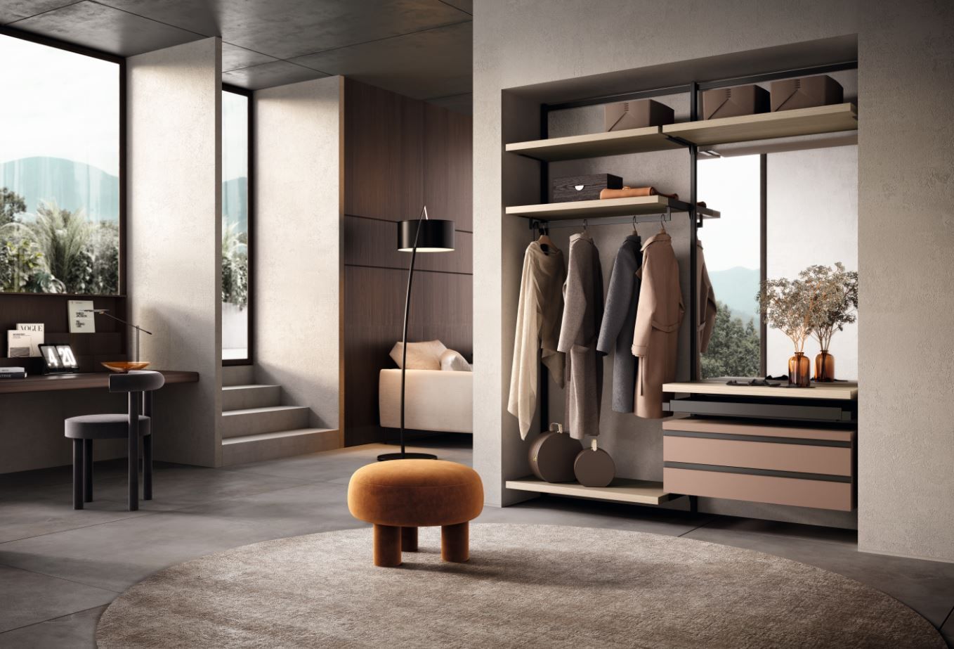 Armadio moderno con vestiti appesi, cassetti e scaffali, accanto a una finestra e una zona soggiorno con scrivania.