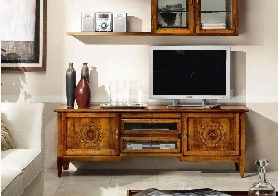 Mobiletto porta TV in legno con mensola e oggetti decorativi.