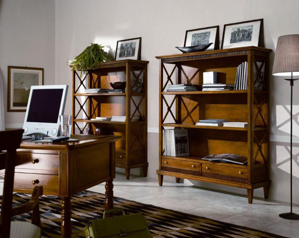 Un ufficio in legno con scrivania, due librerie, una lampada da terra e un computer sulla scrivania.