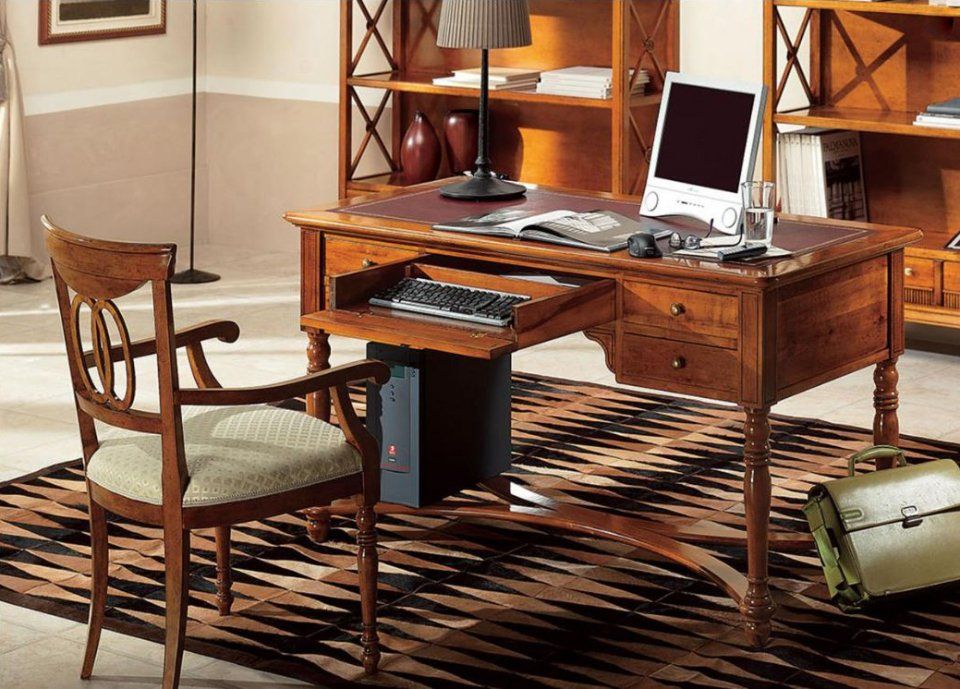 Scrivania in legno con computer, sedia e libreria in uno studio domestico.