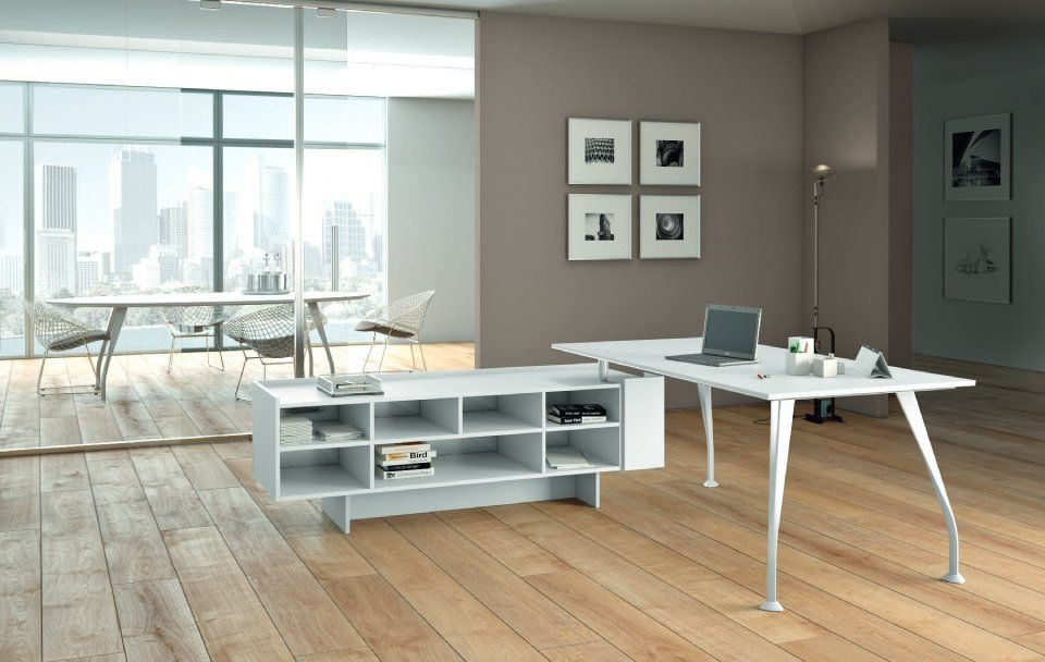 Moderna scrivania bianca da ufficio con spazio di archiviazione, computer portatile e opere d'arte con vista sulla città.
