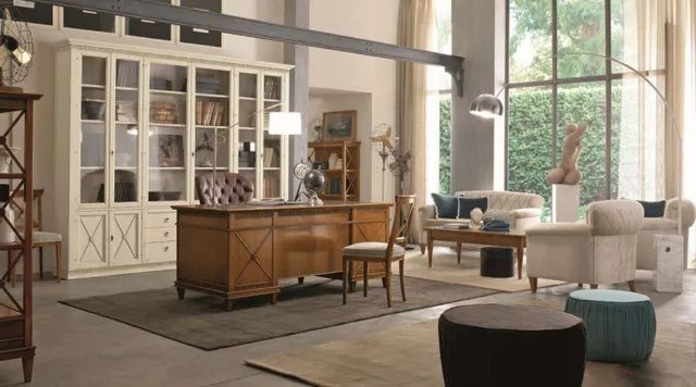 Un ufficio lussuoso con una grande scrivania in legno, librerie e una zona salotto con grandi finestre che si affacciano sul verde.