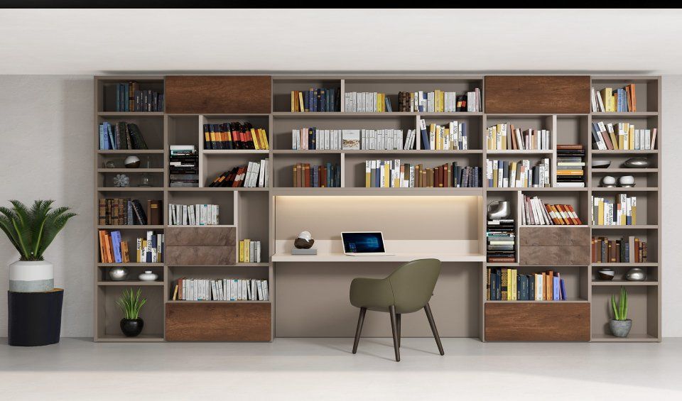 Ufficio domestico integrato con scrivania, sedia e librerie piene di libri e oggetti decorativi.