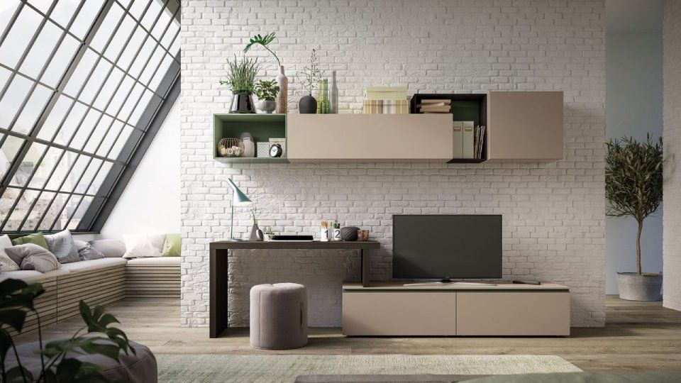 Soggiorno moderno con parete attrezzata beige e verde, TV e tavolo contro una parete di mattoni bianchi.