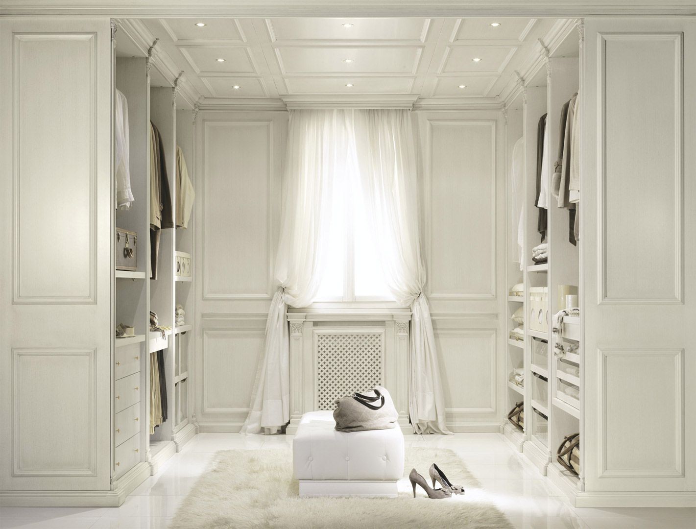 Cabina armadio con mobili decorati color crema, appendiabiti e un tappeto marrone.