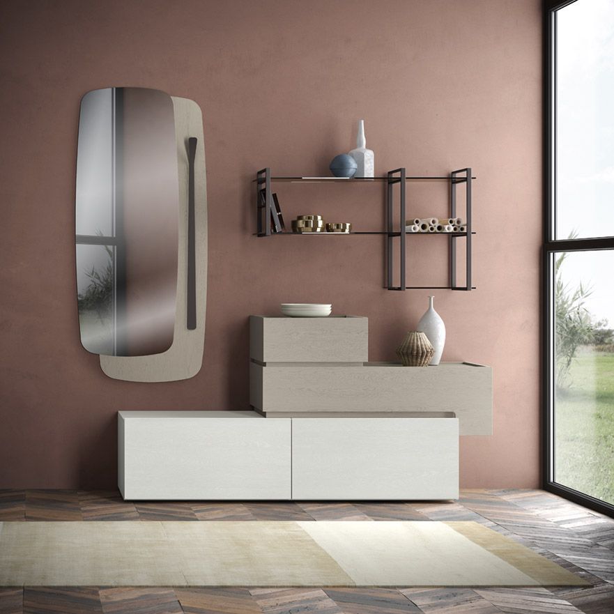 Interno del bagno con specchio, mensole, armadietti, tappeto e finestra con vista su un paesaggio verde.